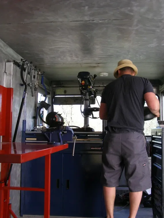 Inside the fully equipped mobile shop with drill press, truing stand, and tool cabinets