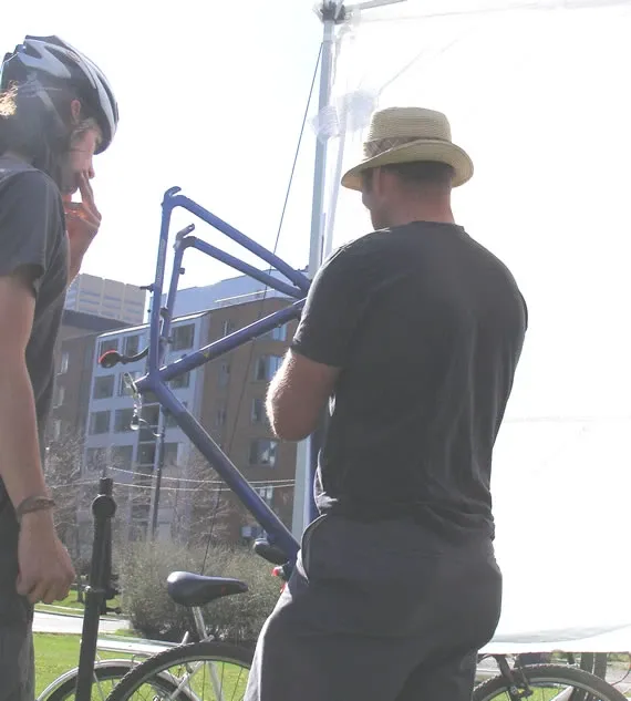 Joe working with an urban cyclist at the mobile repair truck
